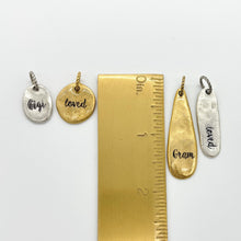 A pic of 4 charms next to a ruler showing their sizes.