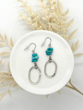 Blue turquoise chip and hammered silver oval drop earrings. These lightweight, geometric dangle earrings feature natural stone elements and a rustic, brushed metal finish, perfect for a modern boho jewelry look.