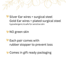 An informational graphic with gold floral line art and heart icons on a white background. It lists product details: silver ear wires are surgical steel and gold are plated surgical steel; both are hypoallergenic and safe for sensitive skin. The text guarantees "NO green skin" and notes that each pair includes a rubber stopper to prevent loss. Finally, it highlights that items arrive in gift-ready packaging, making it ideal for jewelry shoppers looking for quality and convenience.