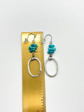 Shows the earrings on a gold ruler. They measure just of 2" in length