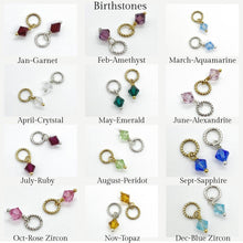 A grid layout titled "Birthstones" displays twelve sets of jewelry charms, one for each month. Each month shows two bicone-shaped crystal charms—one attached to a textured gold jump ring and one to a textured silver jump ring. The colors include deep red for January, purple for February, light blue for March, clear for April, dark green for May, light pink for June, dark pink for July, lime green for August, royal blue for September, rose for October, amber for November, and teal for D