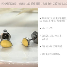 Product infographic for pale yellow resin teardrop stud earrings. A close-up image on the left shows the textured silver-plated bezels. A pink banner at the top reads "HYPOALLERGENIC - NICKEL AND LEAD-FREE - SAFE FOR SENSITIVE EARS." Bullet points on the right detail the specs: .999 fine silver-plated bezel (also in 24k gold plated), 6.6 x 4.6mm size, surgical steel posts & clutch, pale yellow resin filled, and gift-ready packaging.