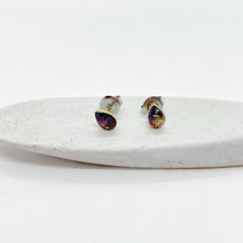 Pair of vibrant multicolor teardrop stud earrings displayed on a white textured ceramic dish against a clean white background. These handmade resin jewelry pieces feature a sparkling mix of magenta, gold, and teal faux druzy flakes in a classic teardrop shape with hypoallergenic gold posts. Perfect as everyday minimalist jewelry or unique handmade gifts for her.