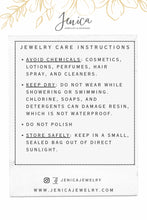 A jewelry care instruction card graphic labeled "Jenica Jewelry & Designs". It outlines four bulleted maintenance tips inside a dotted border. It advises to avoid chemicals like cosmetics, lotions, and perfumes; keep jewelry dry by not wearing it while showering or swimming, noting that chlorine and soaps can damage resin or metals; do not polish; and store safely in a small, sealed bag out of direct sunlight.