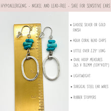 Product infographic for dangle earrings. A top banner reads, "Hypoallergenic - Nickel and lead-free - Safe for sensitive ears." The image shows silver-finish earrings next to a brass ruler, measuring just over 2.25 inches. They feature surgical steel hooks, aqua coral bead chips, and textured oval hoops. Text on the right lists features: silver or gold finish options, bead type, length, hoop dimensions (26.5 x 18.2mm), lightweight feel, surgical steel ear wires, and rubber stoppers.