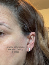 A side-profile view of a woman's ear demonstrating the real-life scale and fit of a tiny marquise-shaped stud earring. The delicate, geometric post earring sits centered on the earlobe to provide a visual reference for its size. Overlay text on the image reads: "Jewelry shown is an example of sizing & shape."