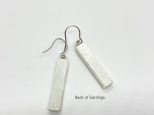 A pair of silver dangle earrings shown from behind against a plain white background. The earrings feature vertical, rectangular bar pendants with a smooth silver back, hanging from simple silver fishhook ear wires. Small text at the bottom right reads "Back of Earrings".