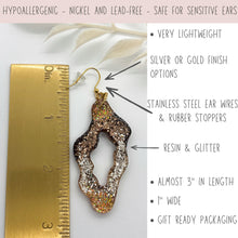 Size chart for handmade glitter resin earrings showing a 3-inch length and 1-inch width against a gold ruler. Features hypoallergenic stainless steel ear wires and rubber stoppers, safe for sensitive ears. These lightweight organic dangles are nickel and lead-free with a brown, gold & champagne gold glitter ombré finish. Text highlights gift-ready packaging and high-quality materials, perfect for boho jewelry lovers seeking comfortable, statement sparkle earrings.