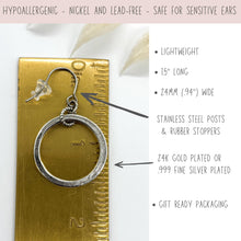 An infographic showing a silver dangle hoop earring laid next to a ruler for scale. Top banner reads "HYPOALLERGENIC - NICKEL AND LEAD-FREE - SAFE FOR SENSITIVE EARS". Bullet points detail features: lightweight, 1.5" long, and 24mm (.94") wide. Arrows point to the stainless steel ear wire with rubber stopper and the circular charm, noting options for 24K gold plated or .999 fine silver plated finish, with gift-ready packaging included.